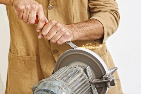 Handwerker schärft sein Werkzeug — Stockfoto