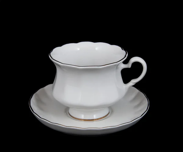 Šálek čaje s talířem na černém pozadí — Stock fotografie