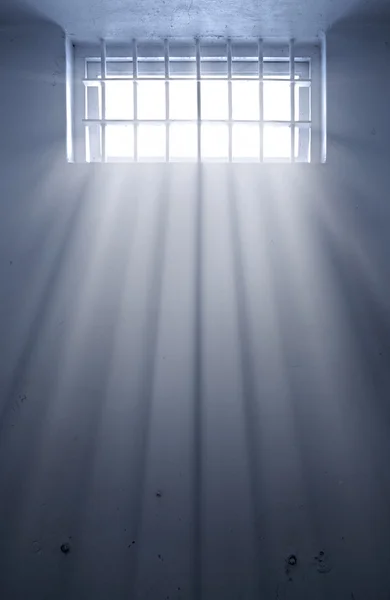 Koude gevangeniscel met zonlicht door raam — Stockfoto