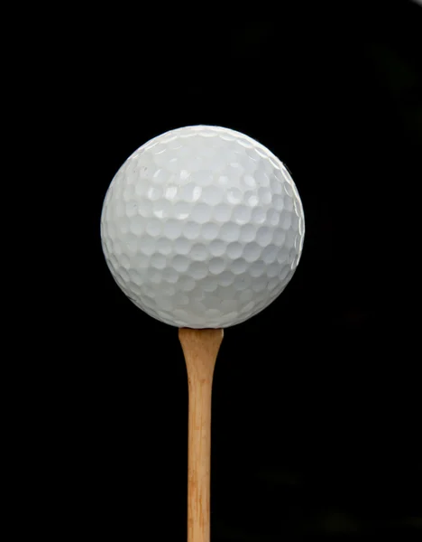 Golfball auf Abschlag auf schwarz — Stockfoto