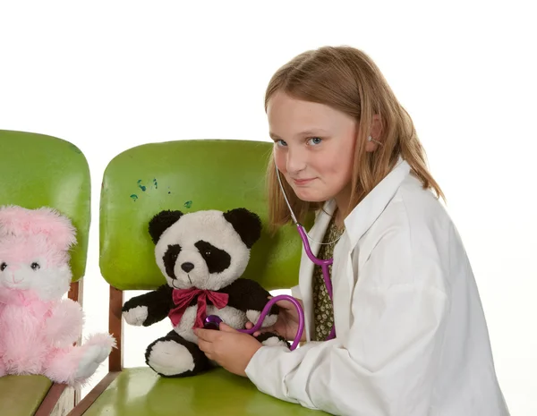 Девочка играет в доктора со своими игрушками — стоковое фото