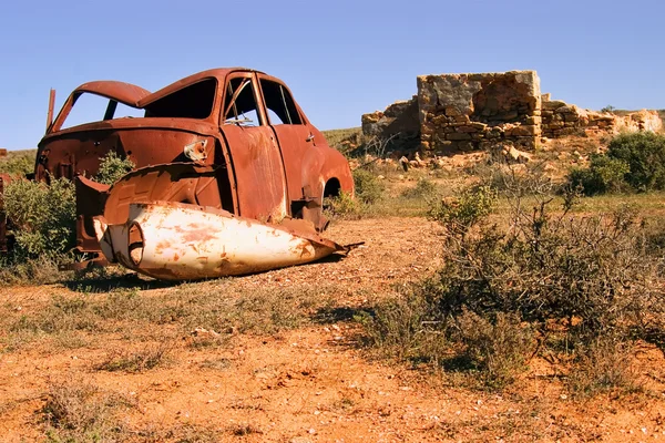 Oude roestende auto en woestijn ruïnes — Stockfoto