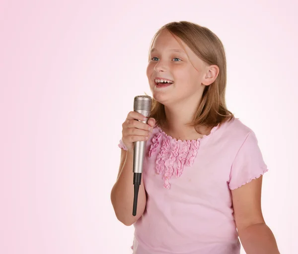 Młoda dziewczyna śpiewa karaoke na biały — Zdjęcie stockowe