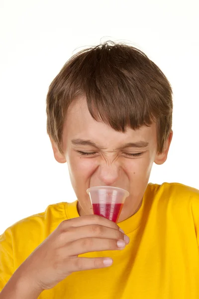 Junge trinkt Medizin auf weiß — Stockfoto