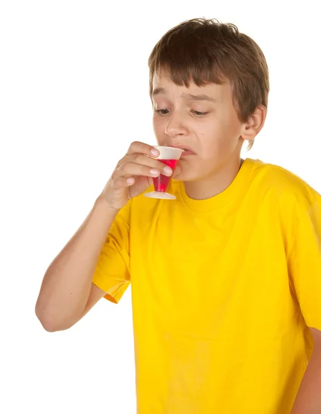 Junge trinkt Medizin auf weiß — Stockfoto