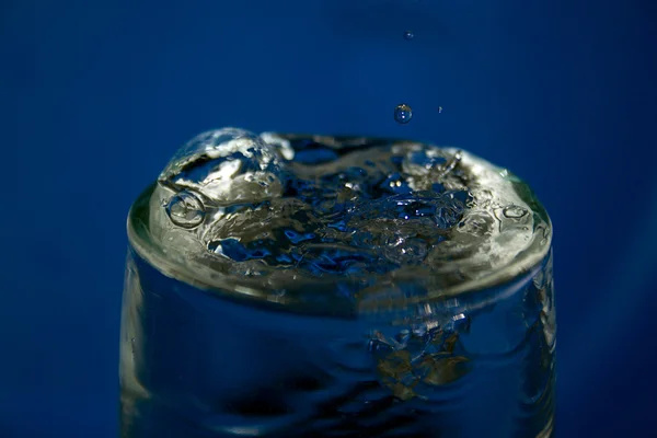 Gotas de água derramadas em um copo de cristal — Fotografia de Stock