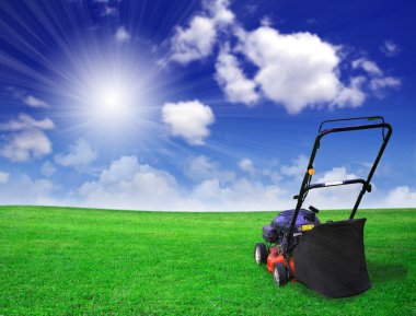 Lawn mower on green field clipart