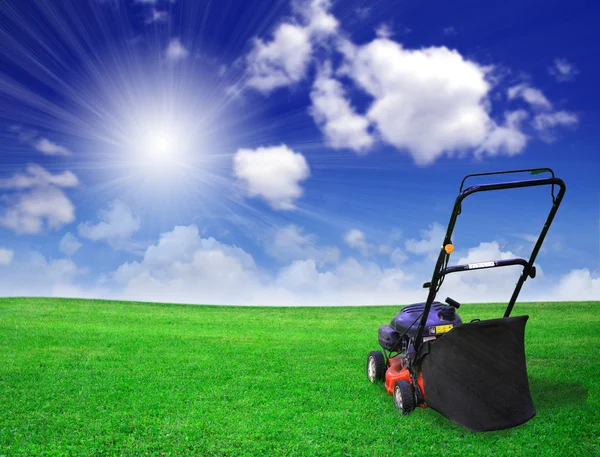 Cortador de grama no campo verde — Fotografia de Stock