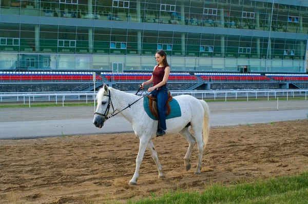 Meisje schrijlings op een paard op een hippodroom — Stockfoto