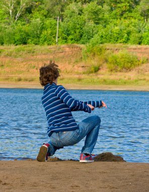 Men throws stone into the river clipart