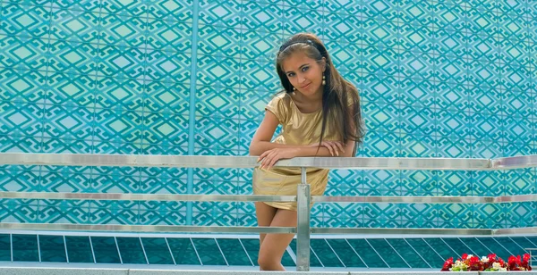 Menina de ouro contra a parede azul — Fotografia de Stock