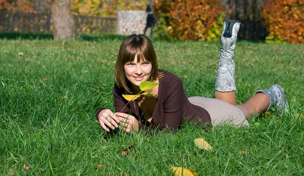 Yeşil çimenlerin üzerinde gülümseyen kız — Stok fotoğraf