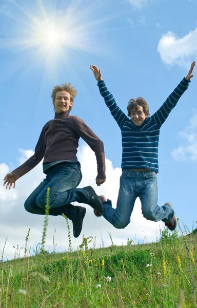 Homens saltando contra a paisagem de verão — Fotografia de Stock
