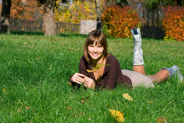 Souriante fille sur une herbe verte — Photo