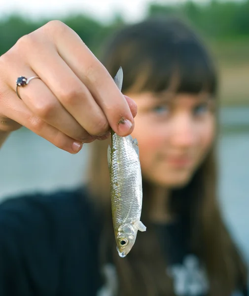 Girl holds the first caught fish in a ha — Stock Photo, Image
