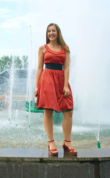 Meisje tegen een stad fontein — Stockfoto