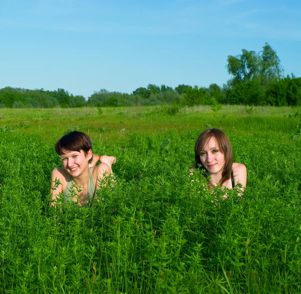 Girls lay in a green summer grass — Stock Photo, Image