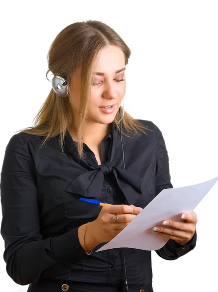 Woman in ear-phones writes something — Stock Photo, Image