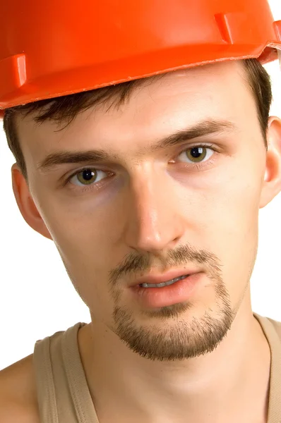 Jovem trabalhador em um capacete de edifício vermelho — Fotografia de Stock