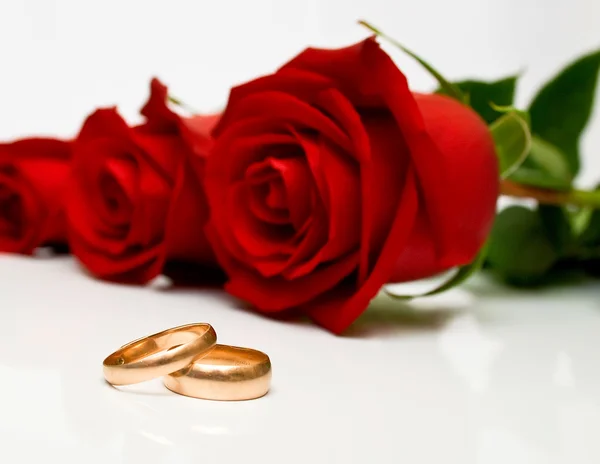 Обручальные кольца и красные розы — стоковое фото