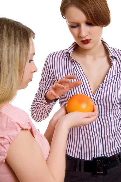 Girl offers the girlfriend a grapefruit — Stock Photo, Image