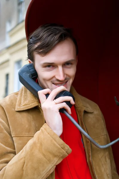 Smiling young men speaking by phone — Stock Photo, Image