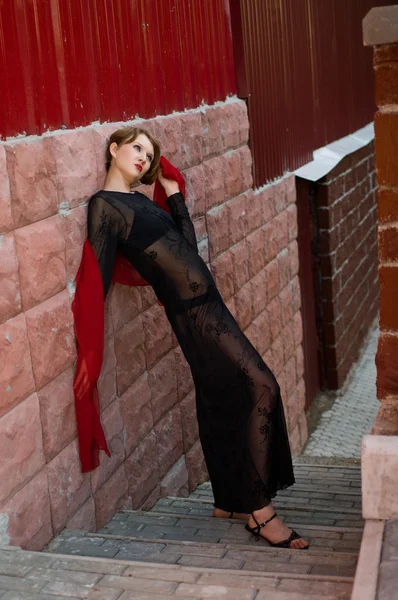 Meisje in zwarte jurk met rode sjaal — Stockfoto