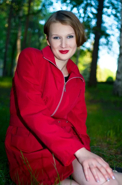 Lachende vrouw in rode regenjas — Stockfoto