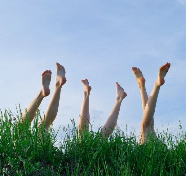Feet of girls laying in a grass — Stock Photo, Image