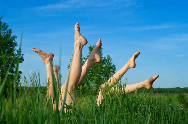 Meninas que põem e tomar banho de sol em uma grama — Fotografia de Stock