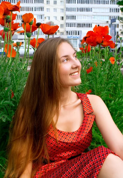 Girl against a lawn with red poppies — Stock Photo, Image