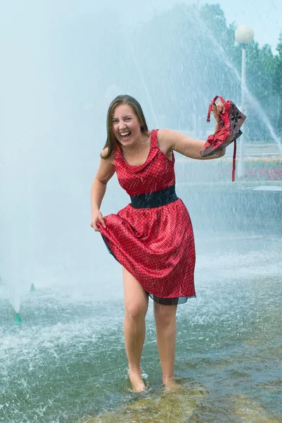 Menina em roupas molhadas em uma fonte da cidade — Fotografia de Stock