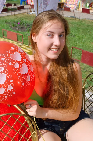 Lachende meisje met een rode ballon — Stockfoto
