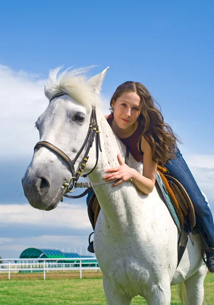 Güzel kız beyaz bir at kucaklar — Stok fotoğraf