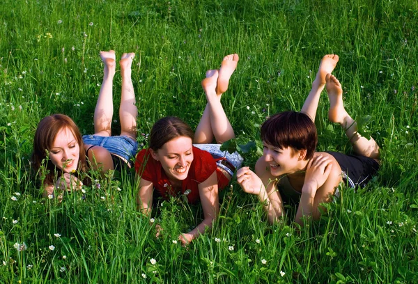Las niñas yacen en una hierba verde de verano —  Fotos de Stock