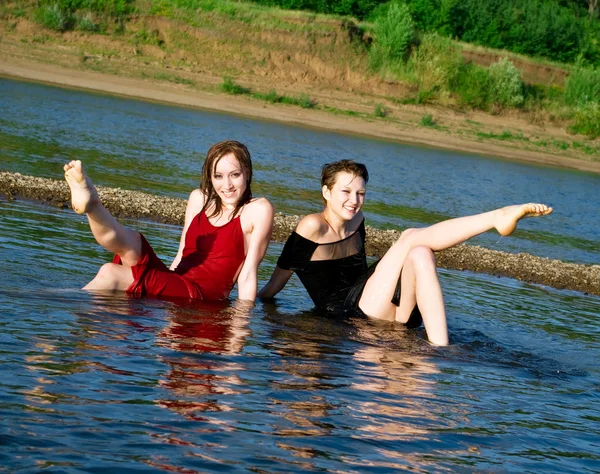 Chicas en vestido mojado se sienta en el agua —  Fotos de Stock