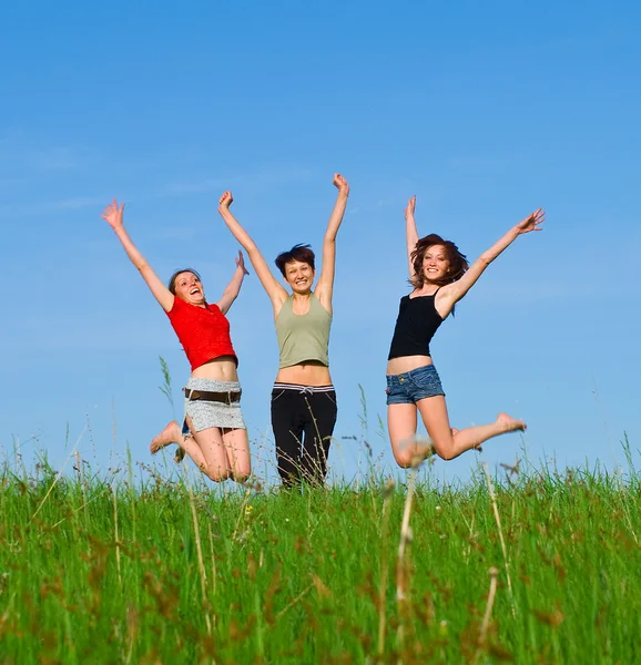 Girls jump on the meadow Stock Picture