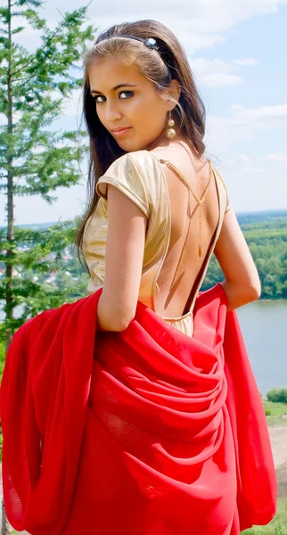 Dziewczyna w złotej sukni z czerwonym szalikiem — Zdjęcie stockowe