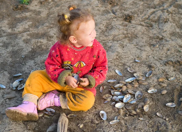 Mädchen spielt mit Muscheln — Stockfoto