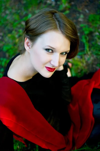 Frauen in schwarzem Kleid mit rotem Schal — Stockfoto