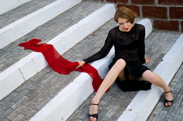 Dziewczyna z czerwonym szalikiem na drabinie kroki — Zdjęcie stockowe