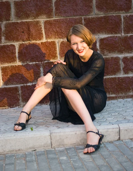 Menina sorridente em vestido preto — Fotografia de Stock