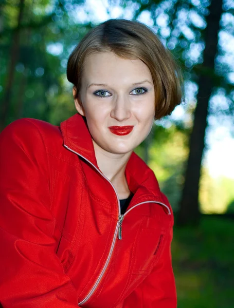 赤いレインコートを着て女性の笑みを浮かべてください。 — ストック写真
