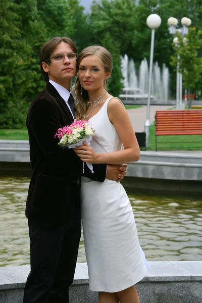 Bruden och brudgummen mot urbana fontän — Stockfoto