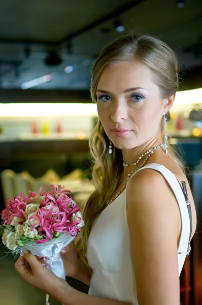 Schöne Braut mit Blumen im Café — Stockfoto