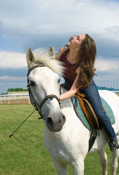 Chica abraza un caballo blanco — Foto de Stock