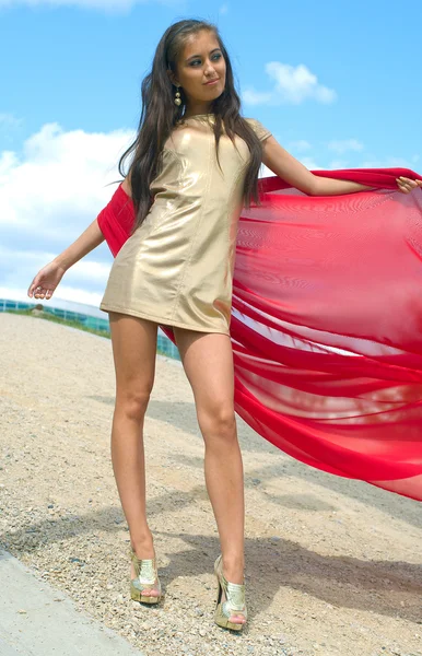 Menina em vestido dourado com cachecol vermelho — Fotografia de Stock