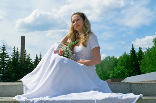 Sposa in un bianco contro cielo blu — Foto Stock