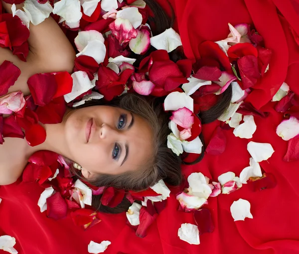 Lachende meisje in roos bloemblad — Stockfoto