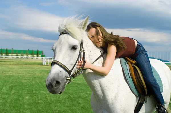 Kız beyaz bir at kucaklar — Stok fotoğraf